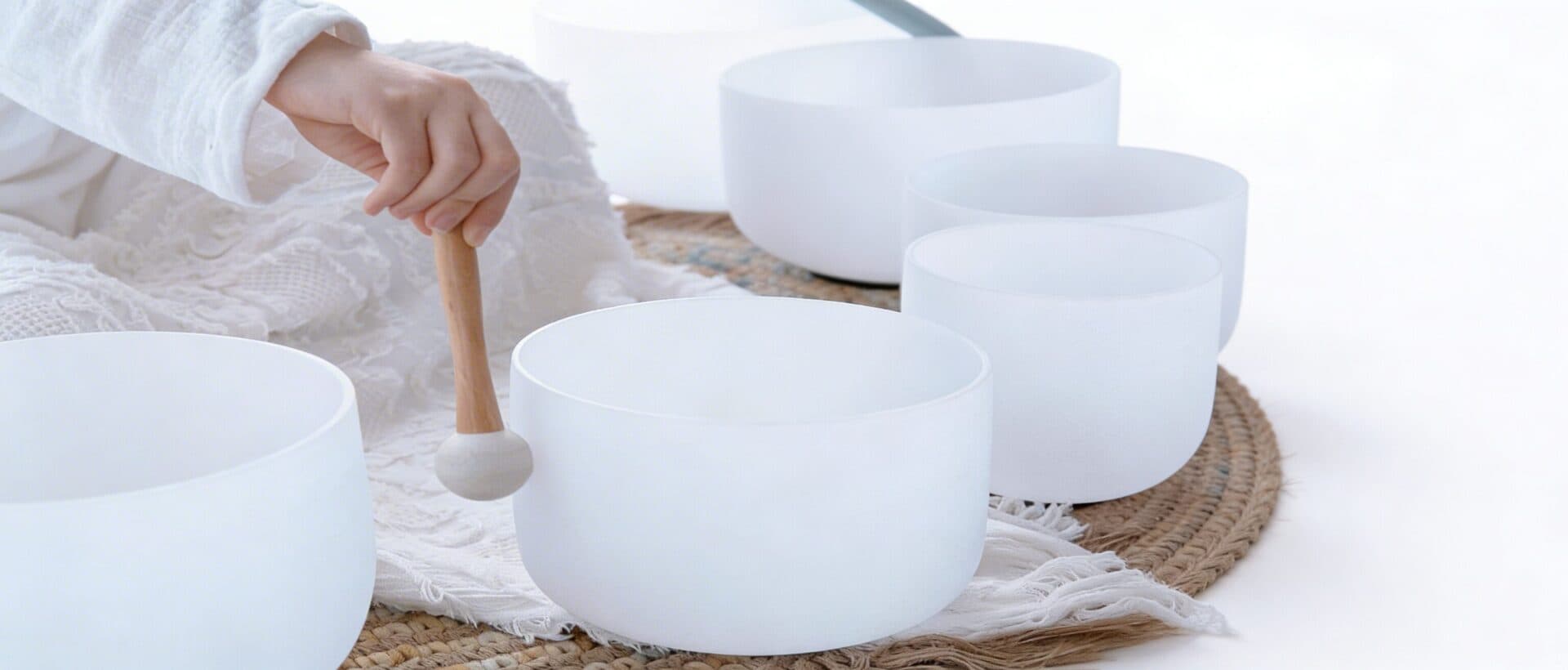 A practitioner playing a crystal singing bowl